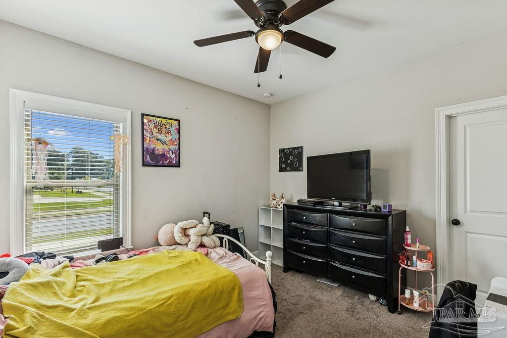 1555 Cadence Loop Cantonment, FL 32533 - Photo 31 of 34 a bedroom with a bed and a flat screen tv