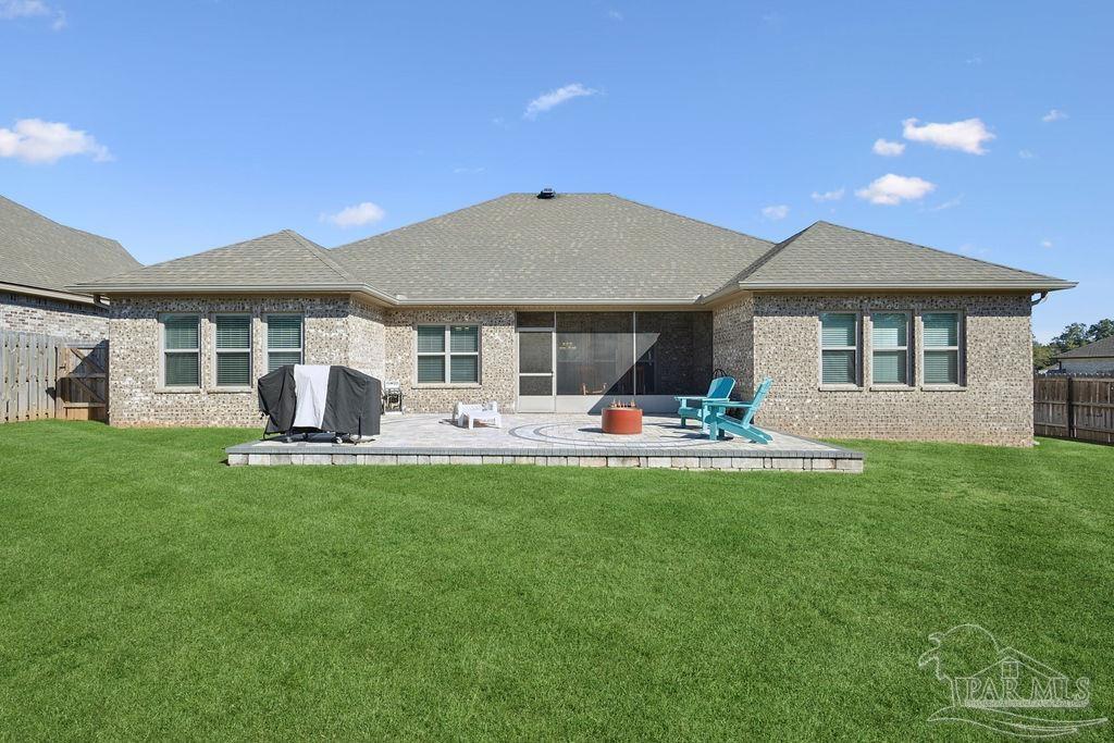 1555 Cadence Loop Cantonment, FL 32533 - Photo 33 of 34 a front view of a house with a garden and patio