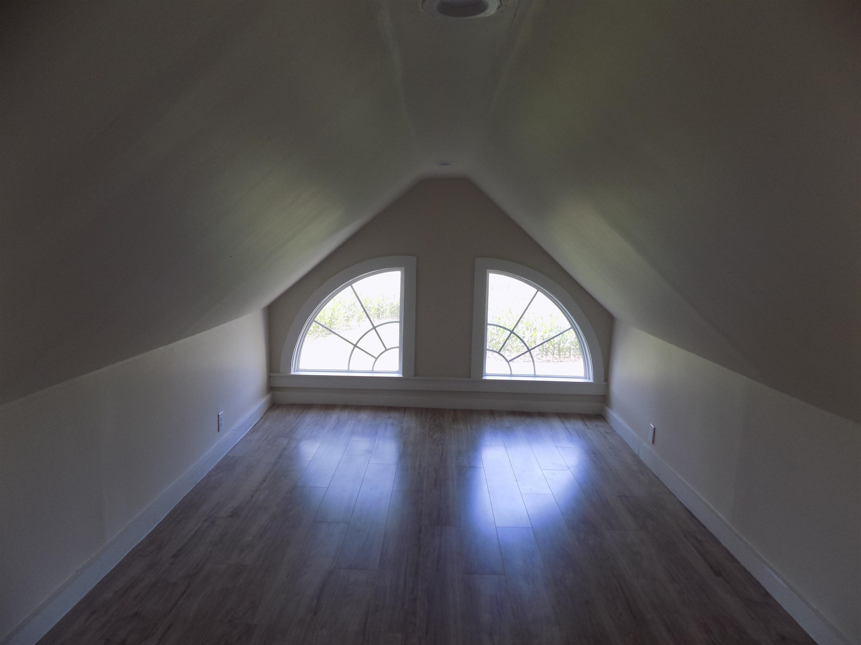 821 Greys Mill Road Louisburg, NC 27549 - Photo 32 of 33 an empty room with wooden floor and windows