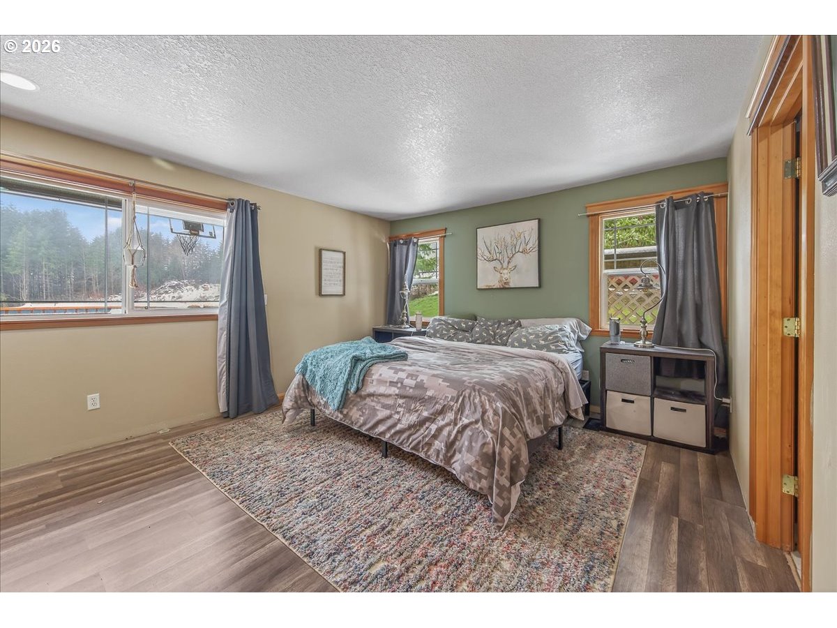 26875 Northwest Bacona Road Buxton, OR 97109 - Photo 32 of 43 a bedroom with a large bed and wooden floor