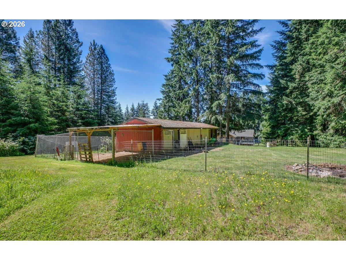 26875 Northwest Bacona Road Buxton, OR 97109 - Photo 5 of 43 a backyard of a house with plants and large trees