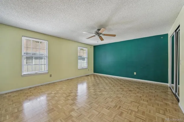 a view of a livingroom with a chandelier fan and windows