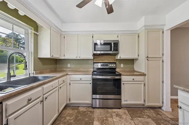 a kitchen with stainless steel appliances granite countertop a refrigerator stove and sink