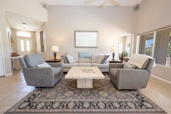 a living room with furniture a rug and a large window