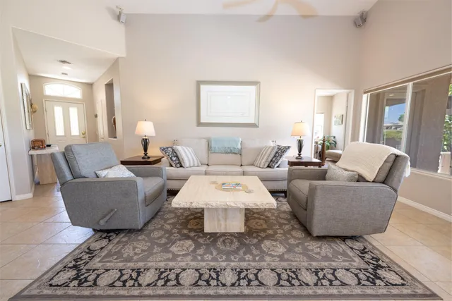 a living room with furniture a rug and a large window