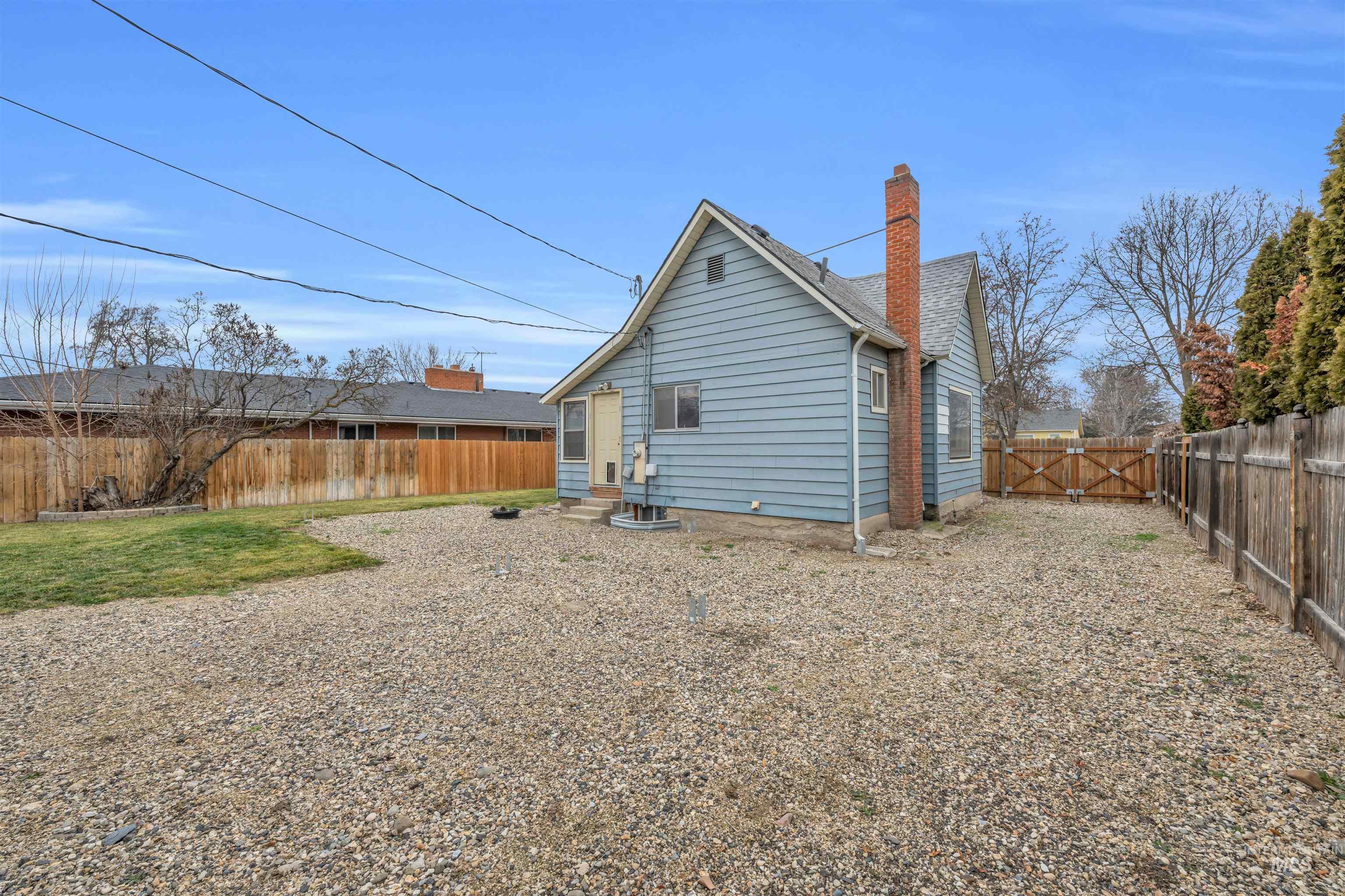 120 South Locust Street Nampa, ID 83686 - Photo 24 of 32 Back of house featuring a fenced backyard, a chimney, and a gate