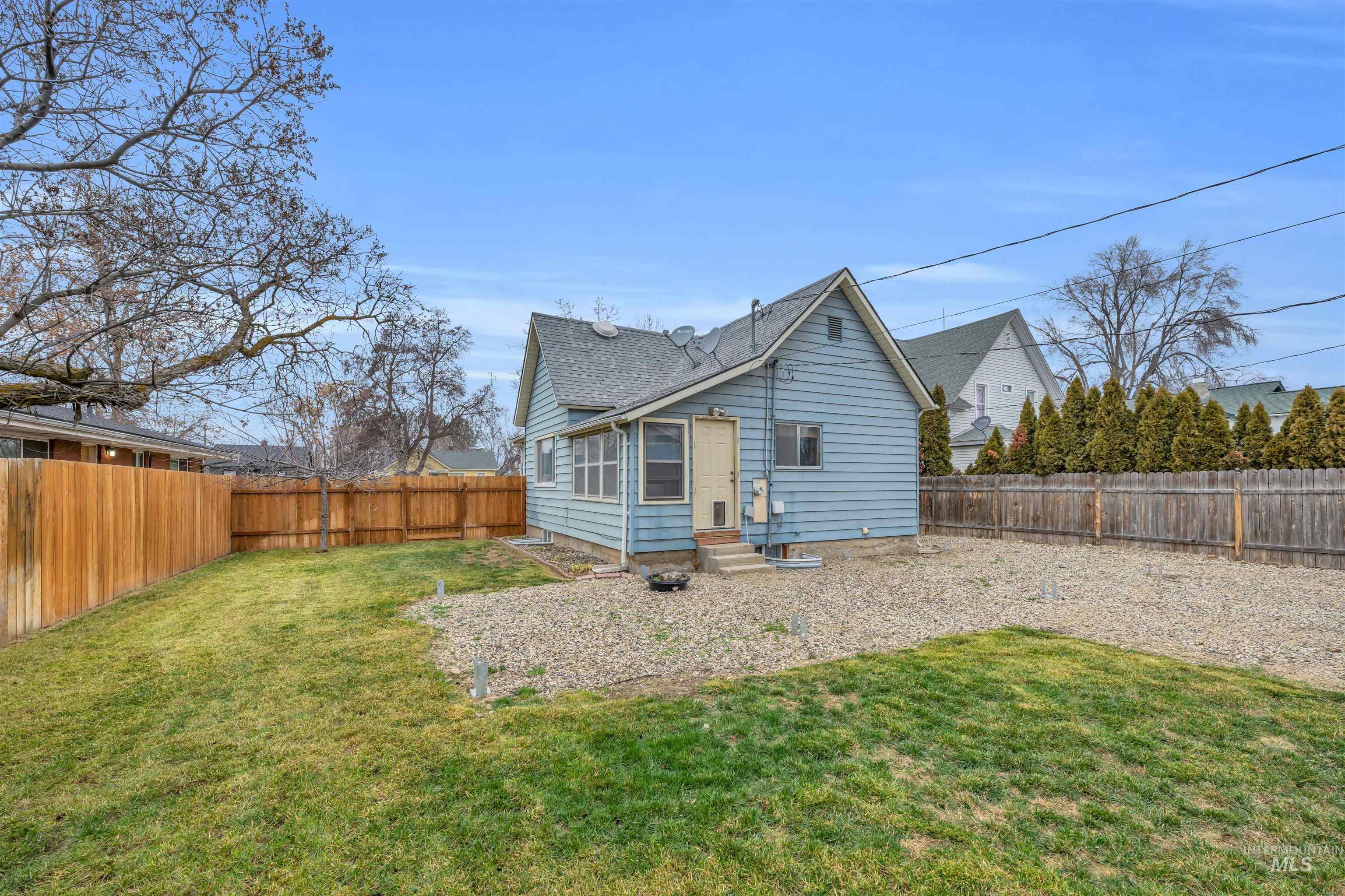 120 South Locust Street Nampa, ID 83686 - Photo 25 of 32 Rear view of house featuring a fenced backyard, entry steps, and a shingled roof
