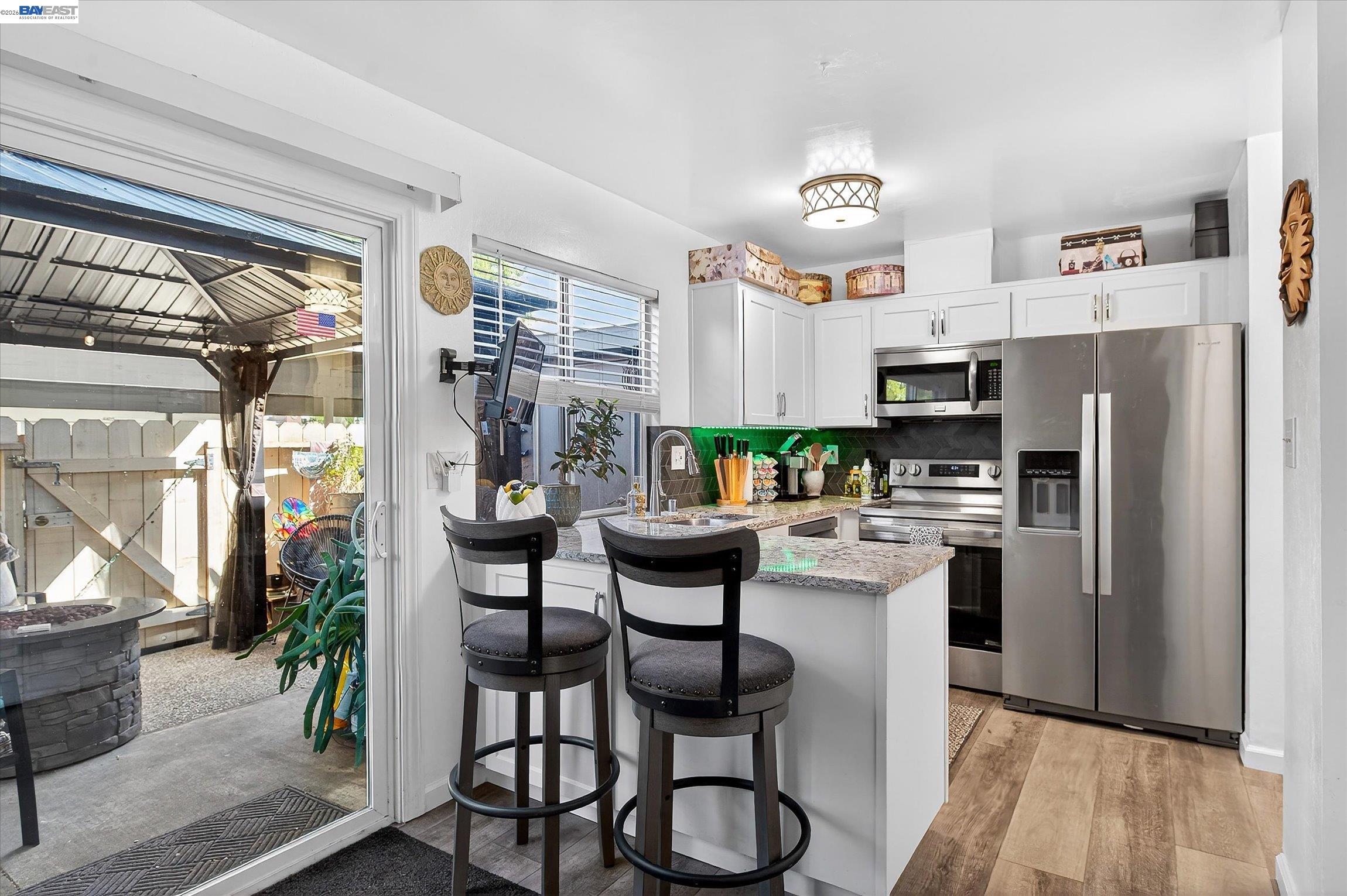 4416 Comanche Way Pleasanton, CA 94588 - Photo 10 of 24 a kitchen with stainless steel appliances a table chairs refrigerator and microwave