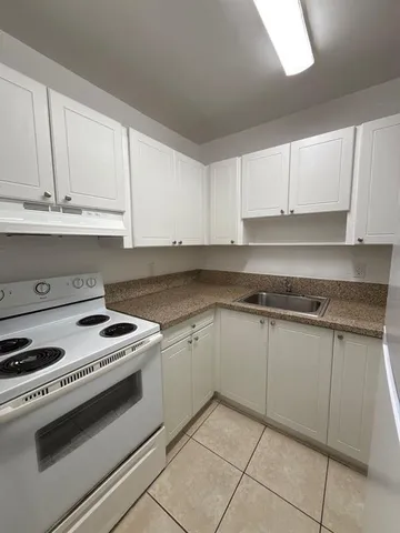 a kitchen with granite countertop white cabinets and white appliances
