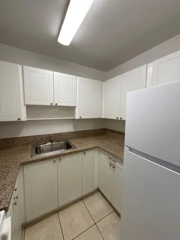 a kitchen with stainless steel appliances granite countertop white refrigerator stove a sink and dishwasher