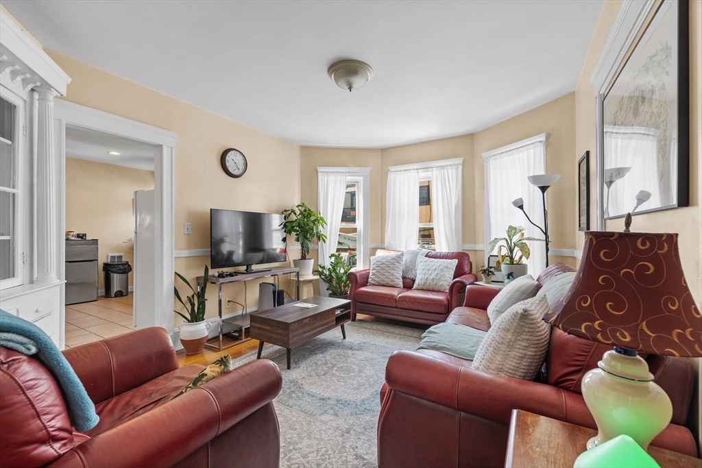 7 Simpson Avenue Somerville, MA 02144 - Photo 3 of 36 a living room with furniture a large window and a flat screen tv
