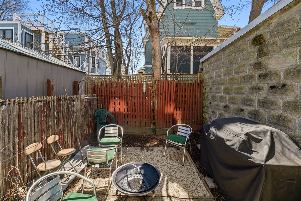 7 Simpson Avenue Somerville, MA 02144 - Photo 35 of 36 a view of a patio with table and chairs with wooden fence