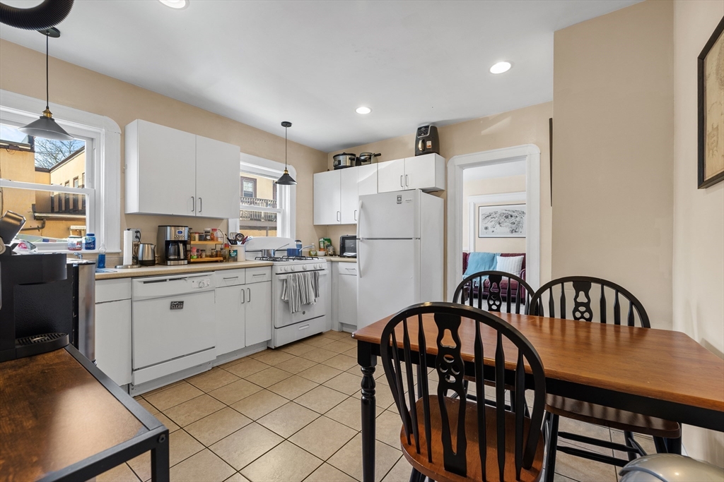 7 Simpson Avenue Somerville, MA 02144 - Photo 7 of 36 a kitchen with appliances a table and chairs