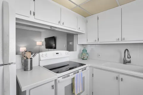 a kitchen with a stove and a white cabinets