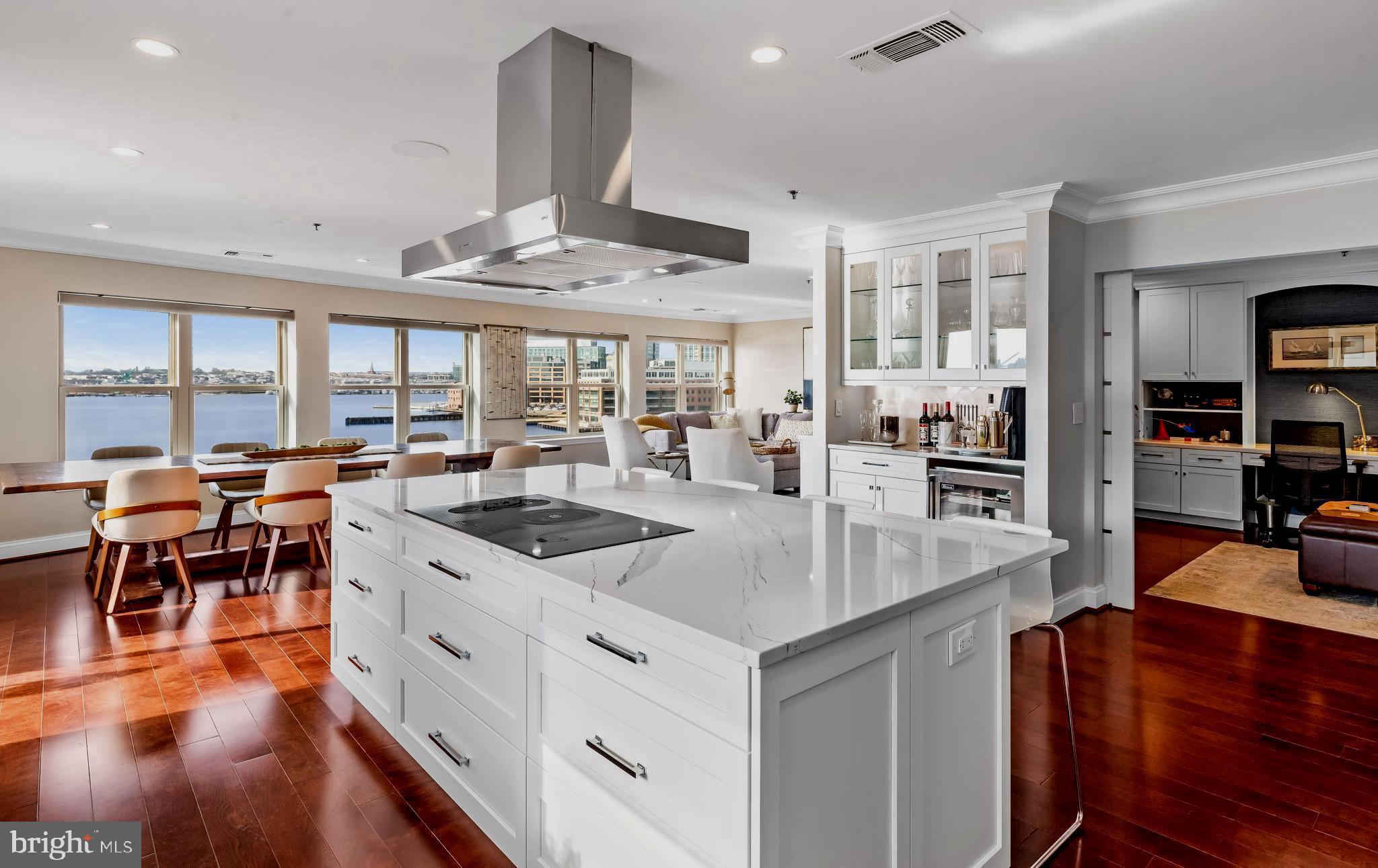 a kitchen with stainless steel appliances granite countertop a table chairs and a view of living room