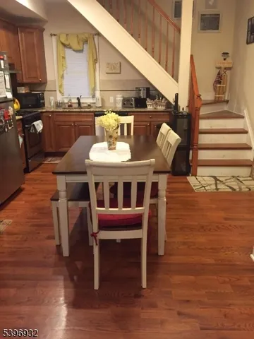 a view of kitchen with wooden floor and dining room