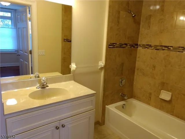 a bathroom with a tub a sink and mirror