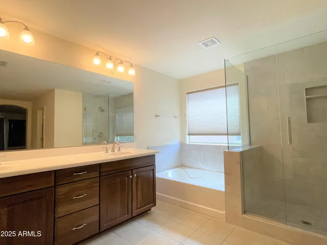 a spacious bathroom with a granite countertop sink mirror and shower