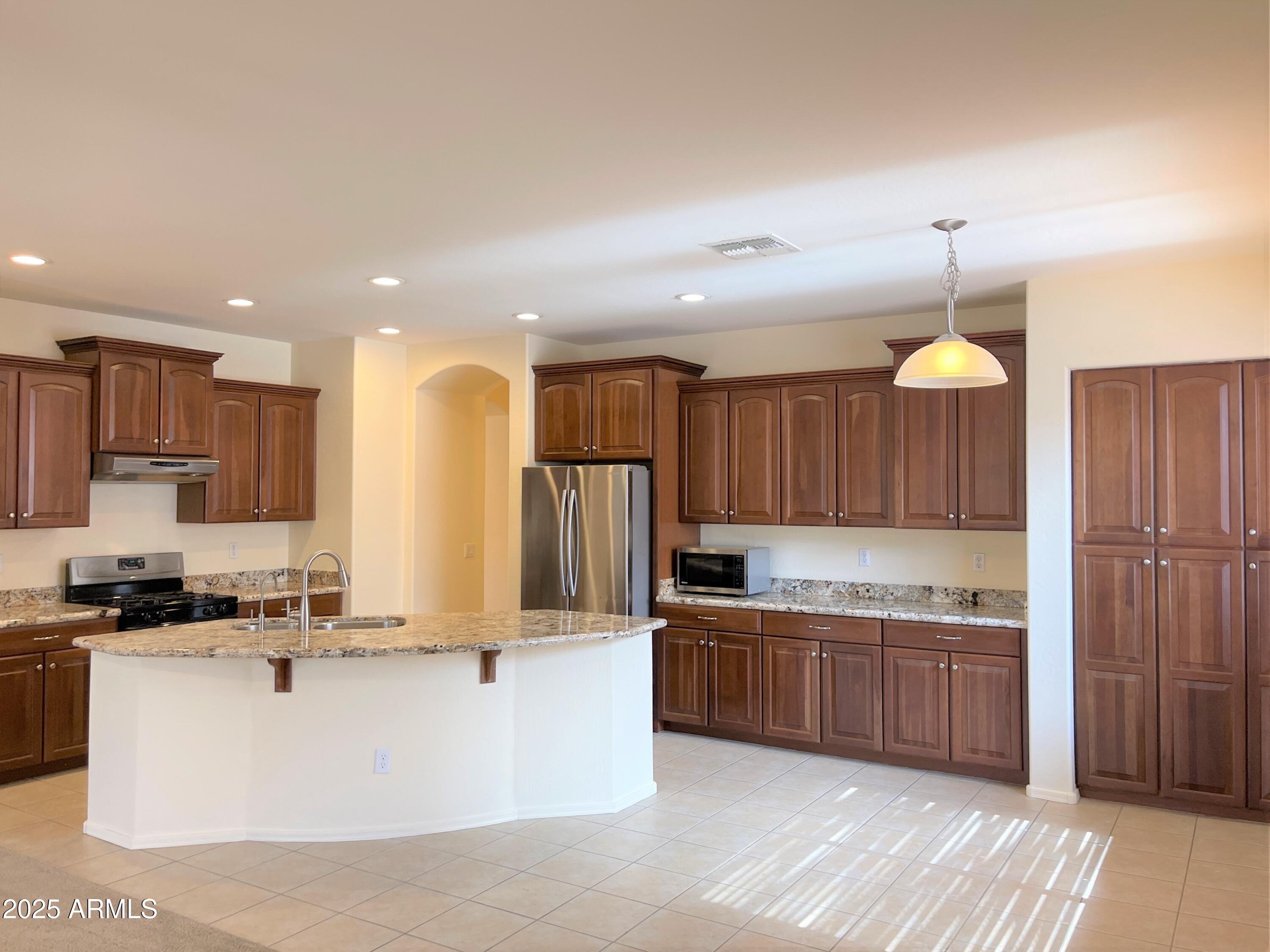 3663 East Sparrow Place Chandler, AZ 85286 - Photo 4 of 32 a large kitchen with kitchen island a sink stainless steel appliances and cabinets