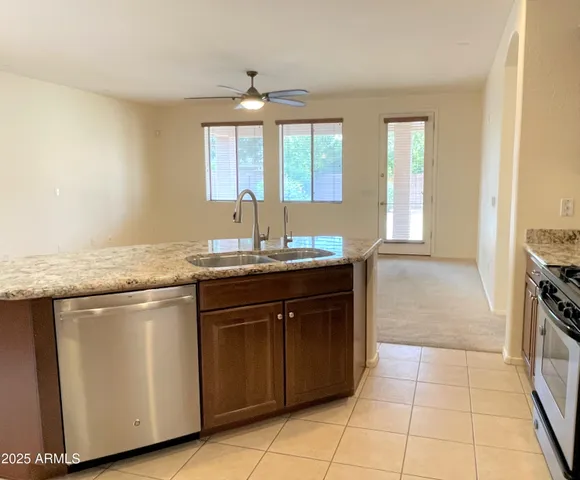 a kitchen with stainless steel appliances granite countertop a sink and a stove