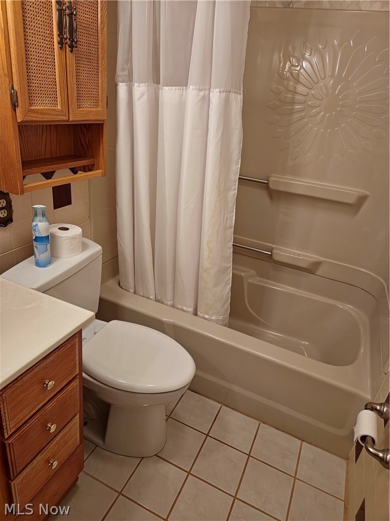 39195 Johnnycake Ridge Road Willoughby, OH 44094 - Photo 13 of 22 Full bathroom with tile flooring, shower / tub combo with curtain, vanity, and toilet
