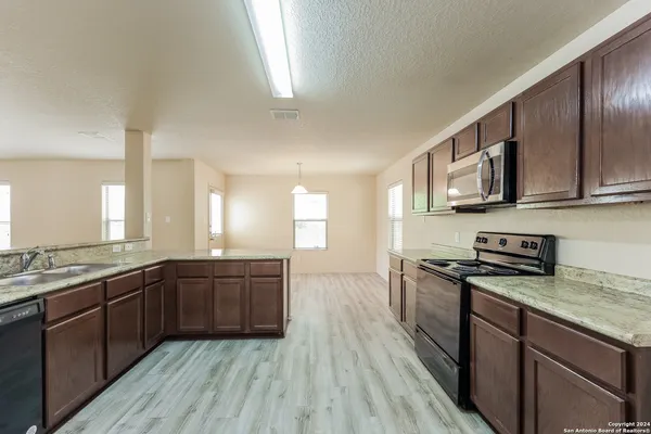 a large kitchen with wooden floors and stainless steel appliances