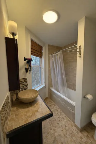 a bathroom with a sink a toilet and shower