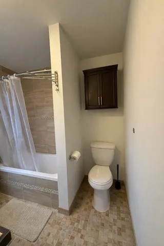 a bathroom with a toilet and a shower