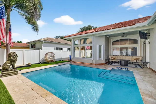 a patio with a table and chairs and a barbeque