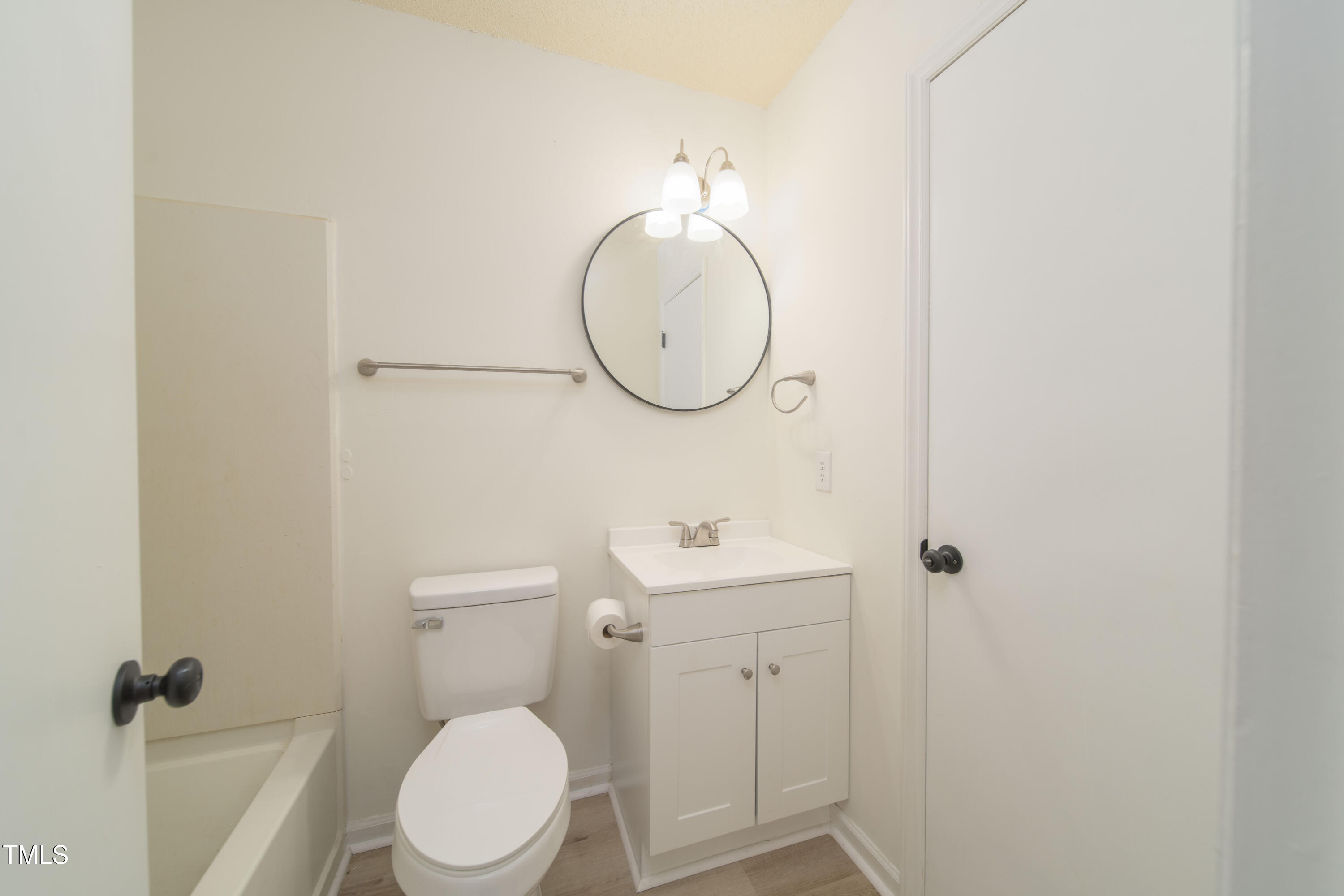 4258 Kaplan Drive Raleigh, NC 27606 - Photo 14 of 20 a bathroom with a toilet a sink and mirror