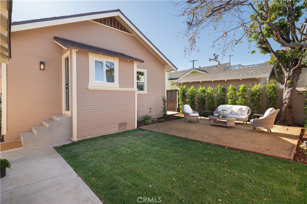 4245 East 6th Street Long Beach, CA 90814 - Photo 18 of 27 a front view of a house with a garden and patio