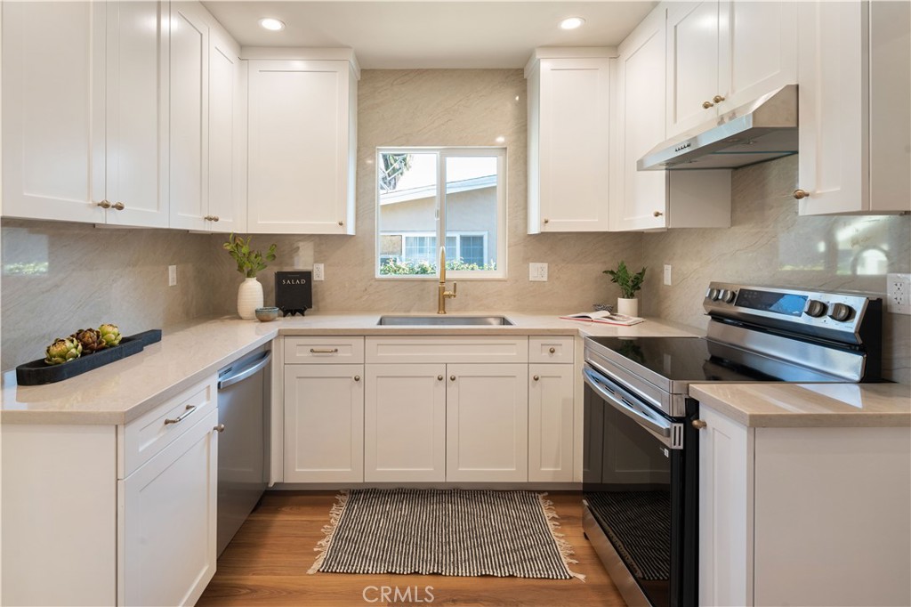 4245 East 6th Street Long Beach, CA 90814 - Photo 9 of 27 a kitchen with cabinets appliances and a window