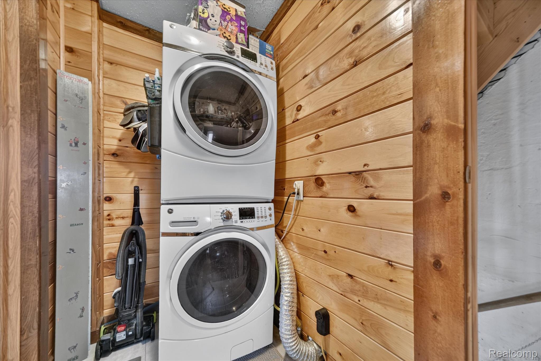 9413 Rives Junction Road Rives Junction, MI 49277 - Photo 15 of 43 Wood-paneled wall with stacked washer and dryer appliances