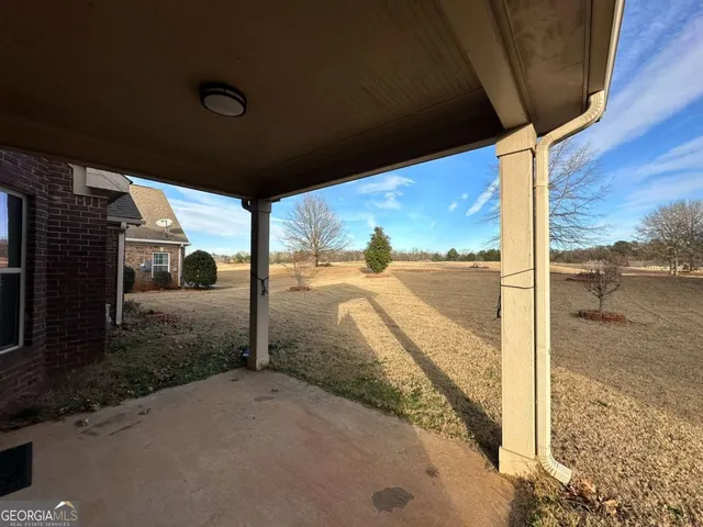 an empty room with windows and fireplace