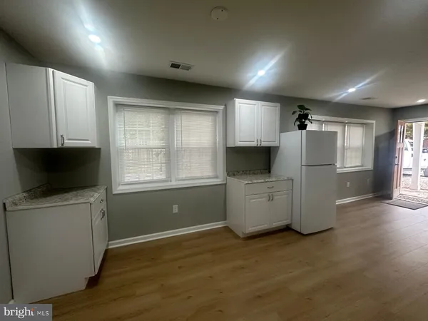 a kitchen with a refrigerator a stove top oven and cabinets