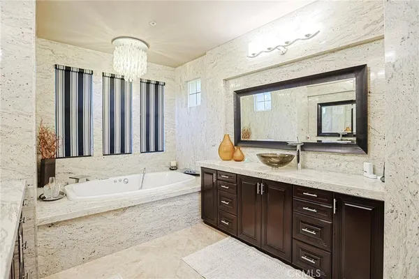 a bathroom with a tub a sink and mirrors