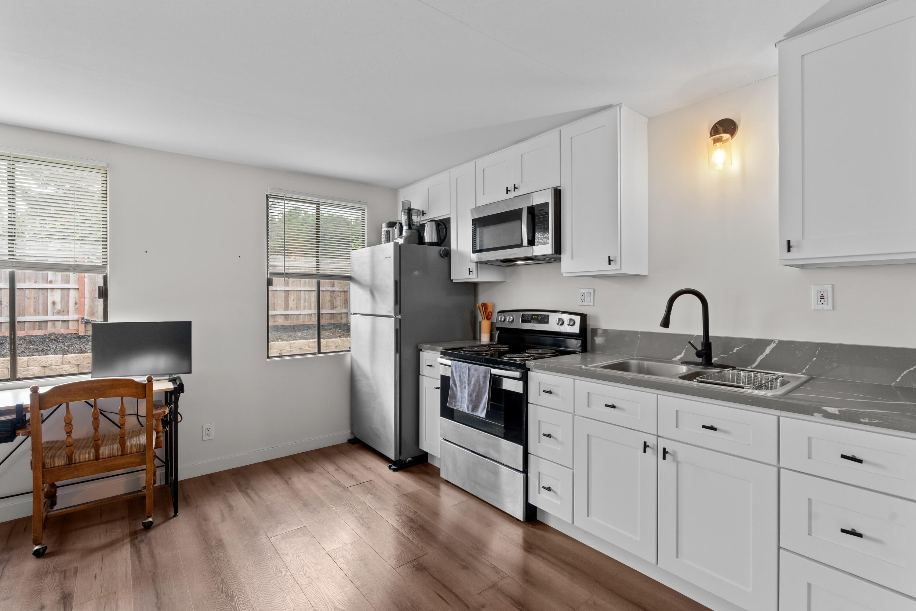 1220 West Lime Avenue Lompoc, CA 93436 - Photo 27 of 48 a view of kitchen with stainless steel appliances granite countertop a stove top oven a sink and dishwasher with wooden floor