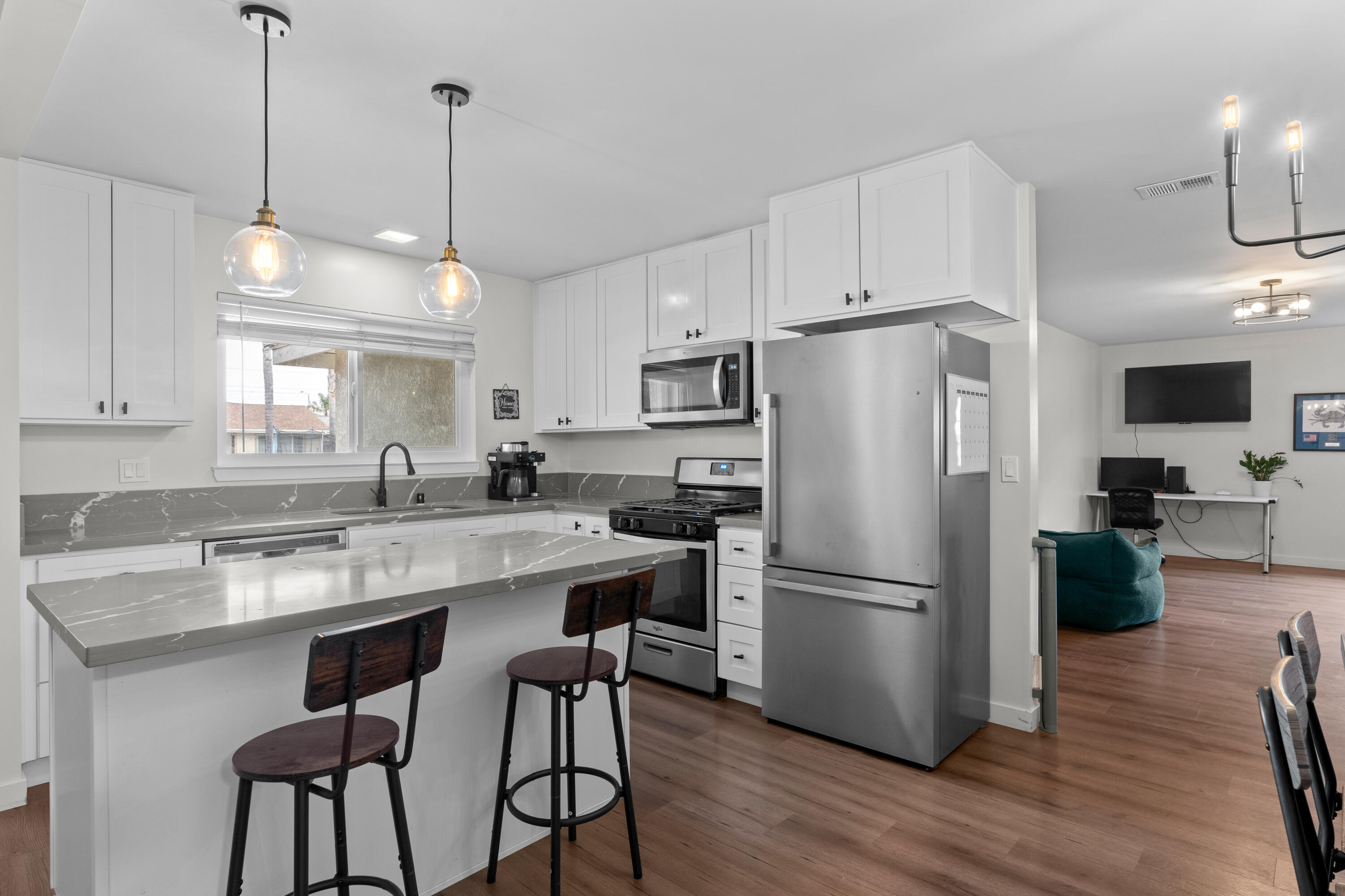 1220 West Lime Avenue Lompoc, CA 93436 - Photo 10 of 48 a kitchen with stainless steel appliances granite countertop a refrigerator a sink dishwasher a oven a dining table and chairs with wooden floor