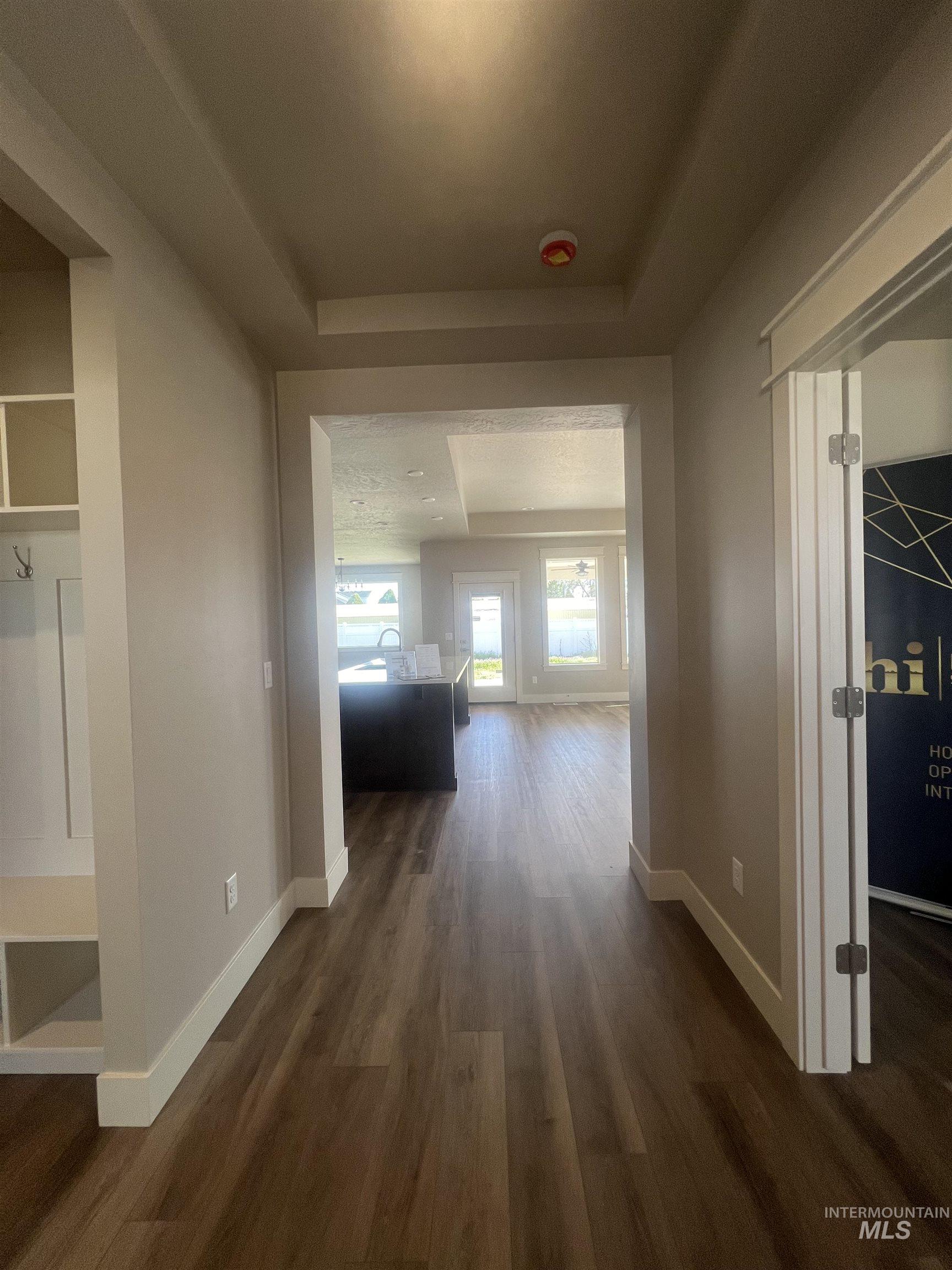 1171 West Recess Way Kuna, ID 83634 - Photo 13 of 15 Open-concept interior featuring wood-finish flooring, recessed lighting, white trim, and a built-in hall tree