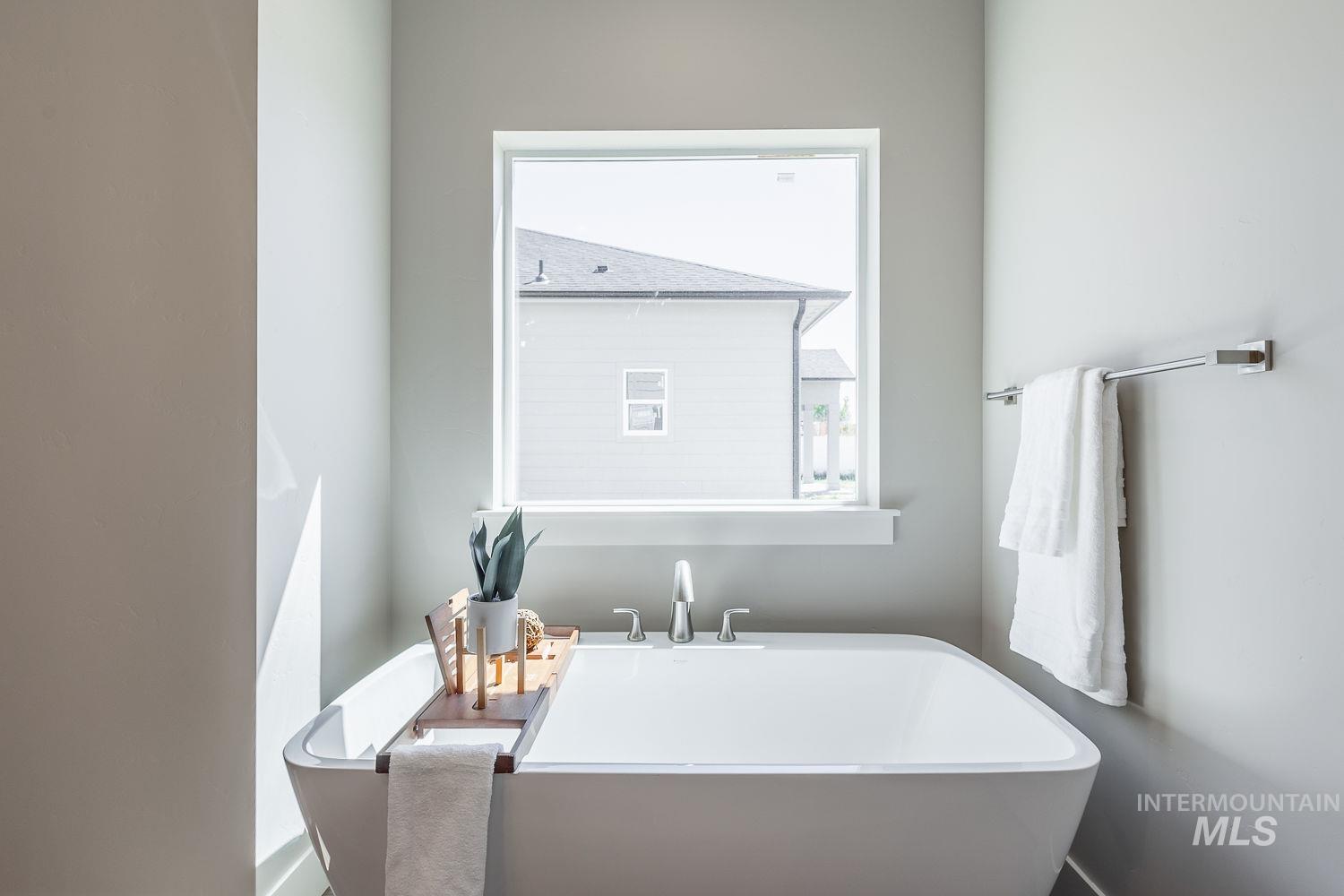 1171 West Recess Way Kuna, ID 83634 - Photo 15 of 28 Freestanding soaking tub with a deck-mounted faucet and a prominent window