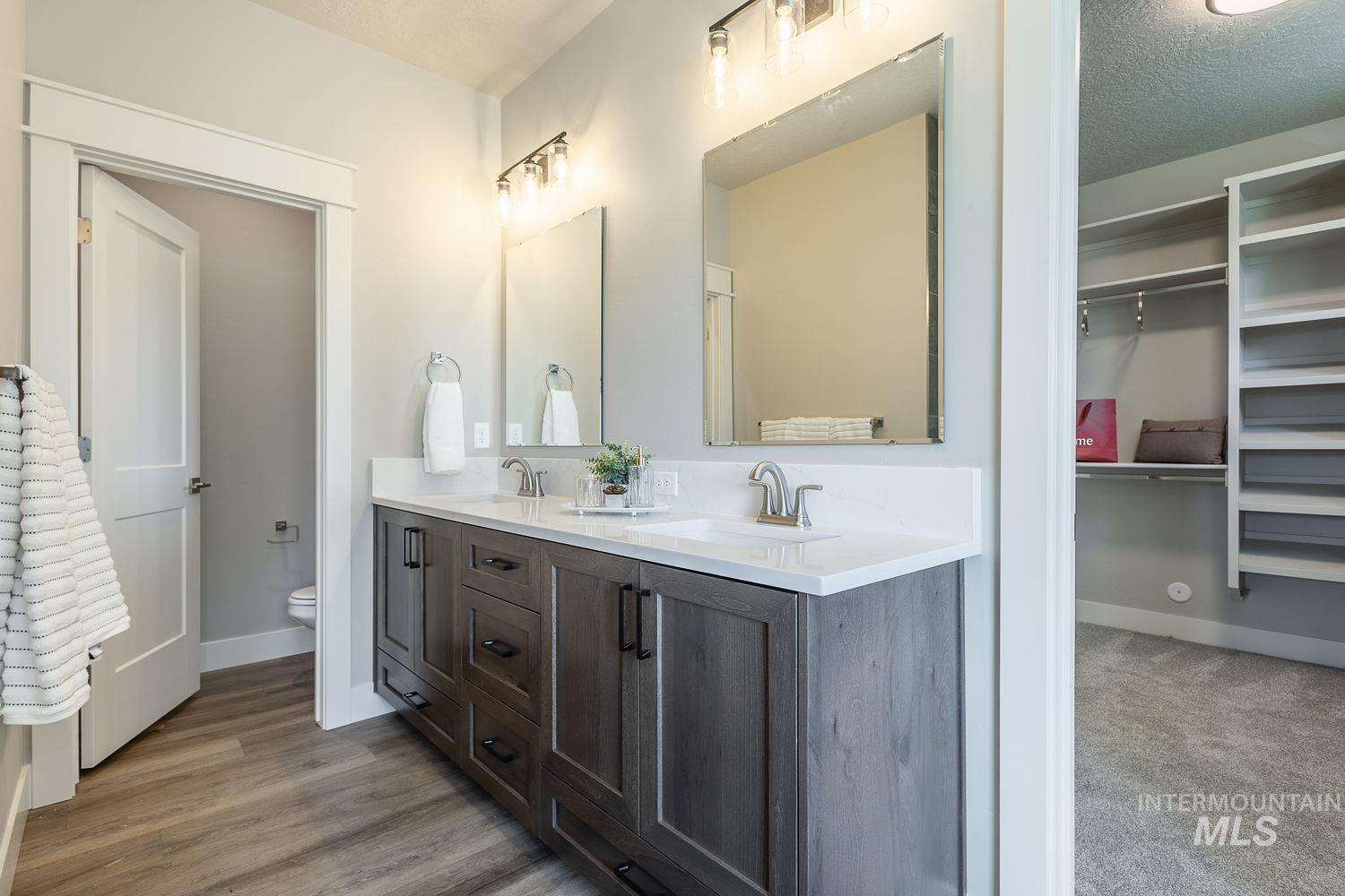 1171 West Recess Way Kuna, ID 83634 - Photo 16 of 28 Dual vanity with stone-finish countertop, wood-finish cabinetry, and individual mirrors