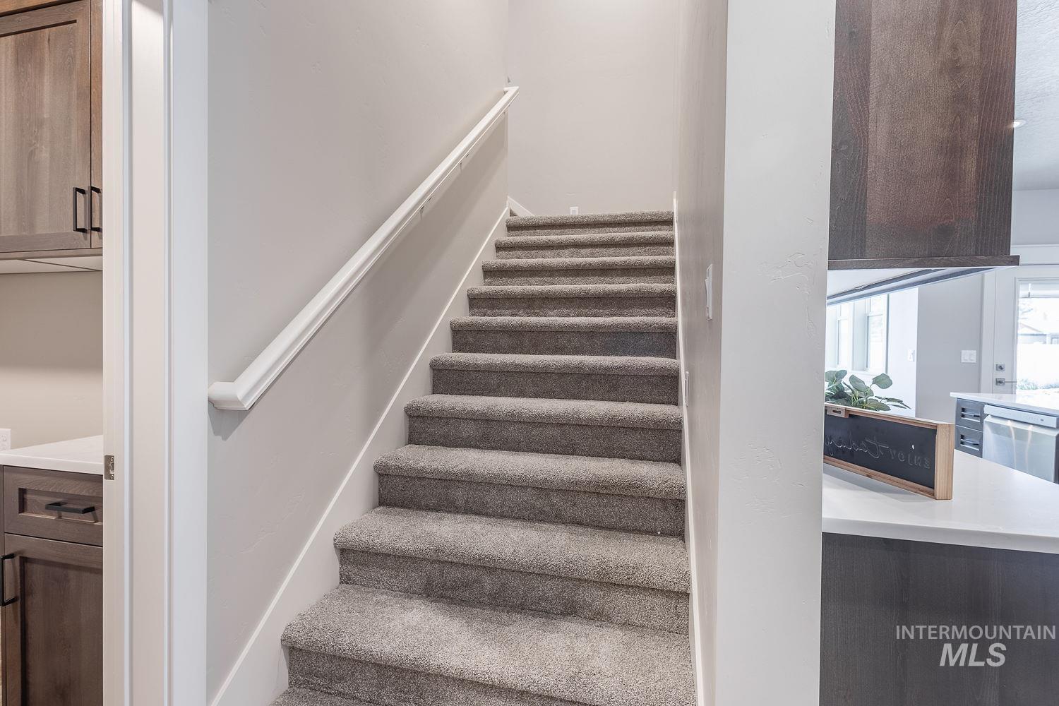 1171 West Recess Way Kuna, ID 83634 - Photo 19 of 28 Carpeted staircase with a white handrail