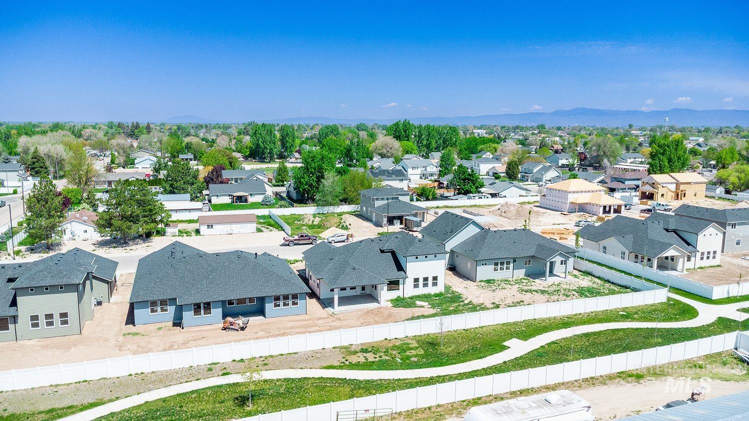 1171 West Recess Way Kuna, ID 83634 - Photo 2 of 28 Aerial perspective of a developing residential area with multiple single-story homes featuring dark shingle roofs and light-colored siding