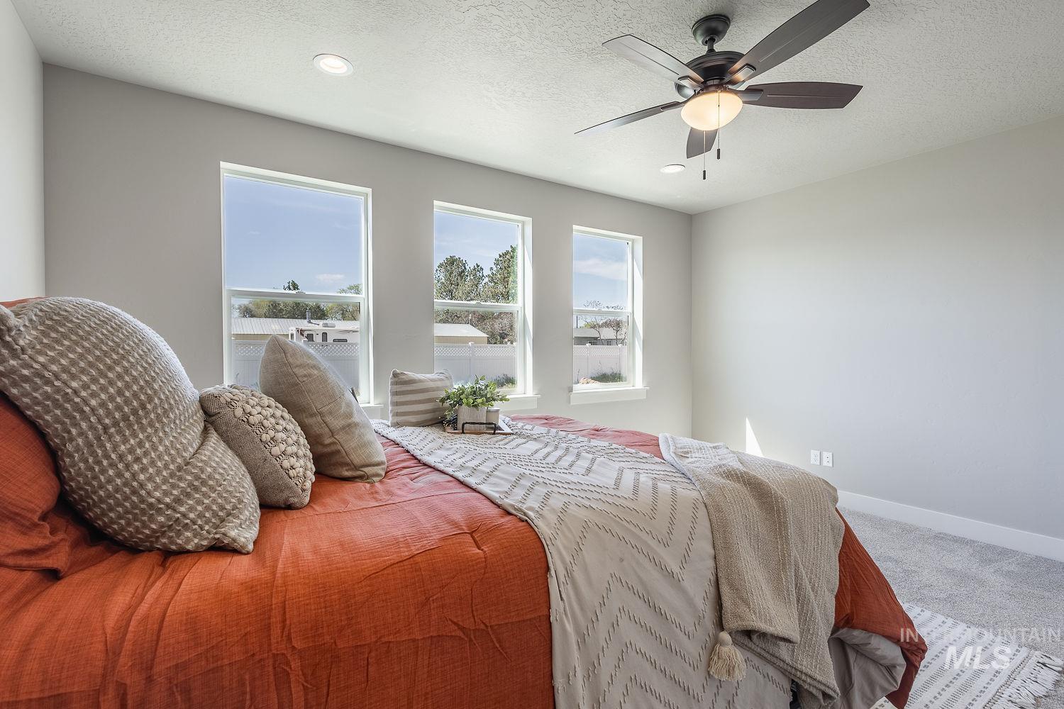 1171 West Recess Way Kuna, ID 83634 - Photo 10 of 28 Bedroom featuring three large windows, recessed ceiling lighting, a ceiling fan with integrated light, and neutral wall paint