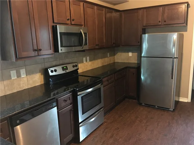 a kitchen with stainless steel appliances granite countertop a refrigerator stove and microwave