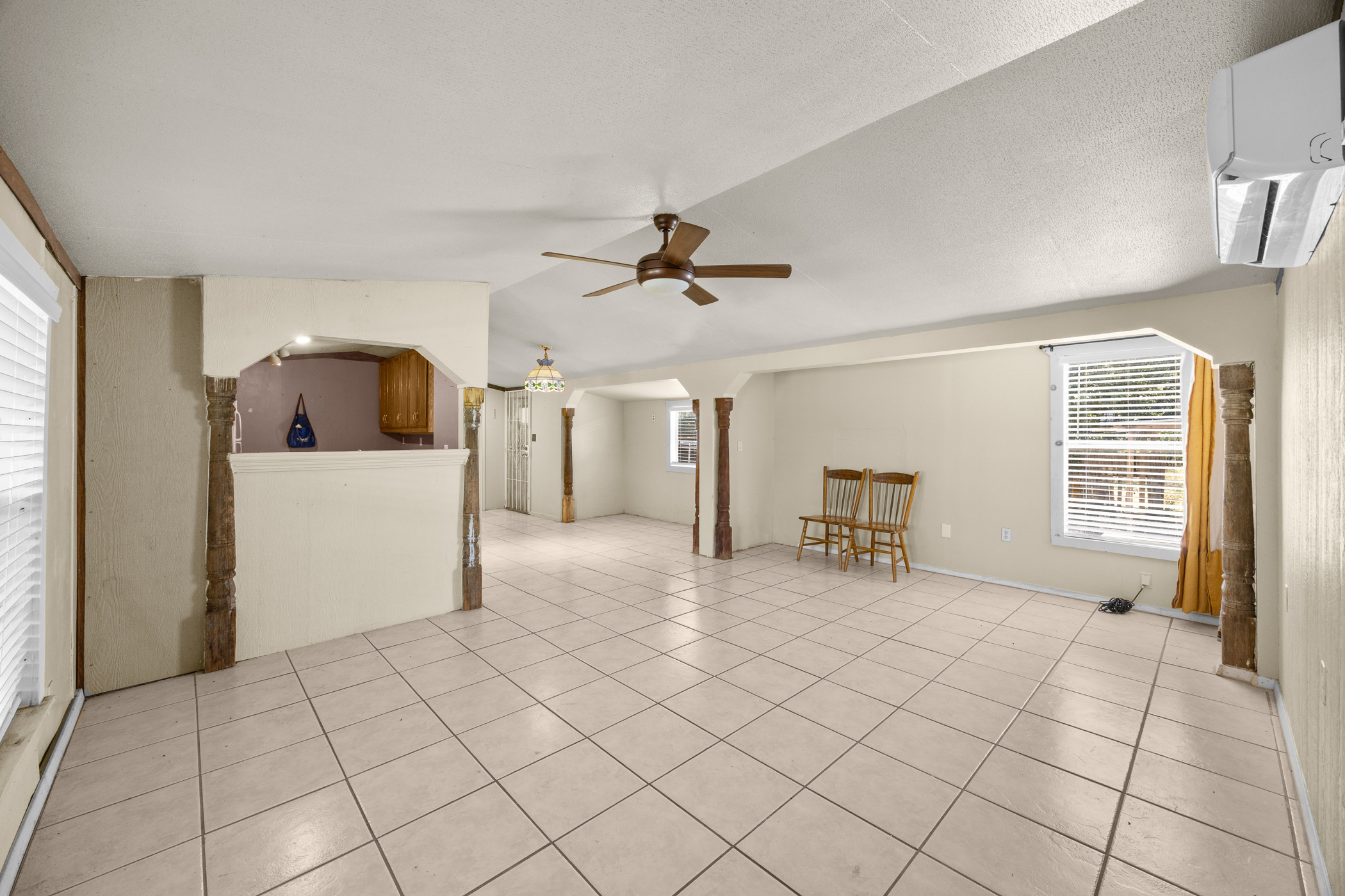 147 Community Center Road Rosanky, TX 78953 - Photo 6 of 33 Unfurnished living room featuring healthy amount of natural light, light tile patterned flooring, vaulted ceiling, and a ceiling fan
