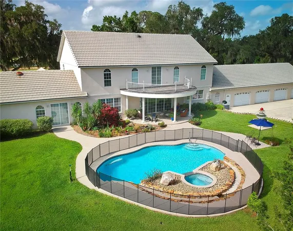 a view of a house with a swimming pool and a yard