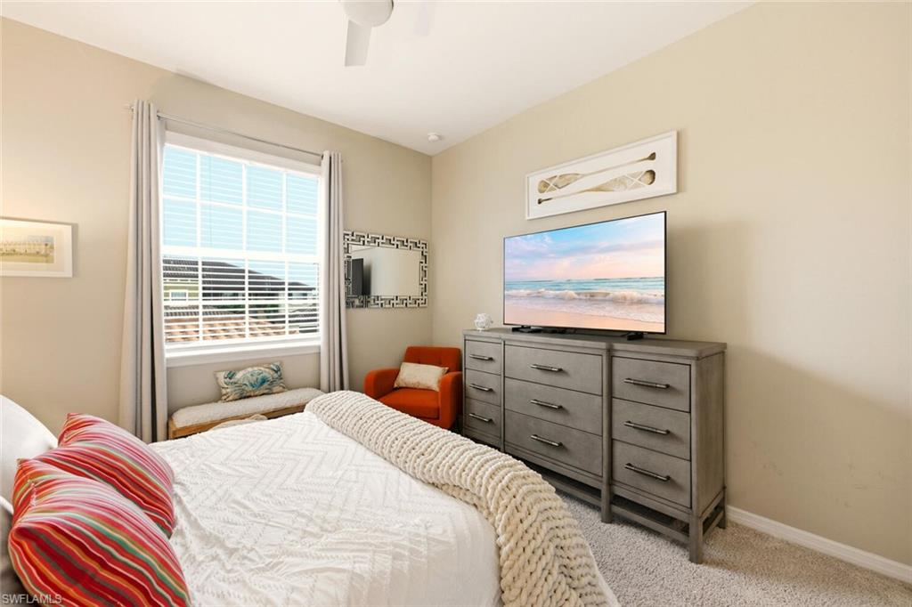9365 Pocida Court, Unit 202 Naples, FL 34119 - Photo 23 of 40 a bedroom with a bed and a flat screen tv