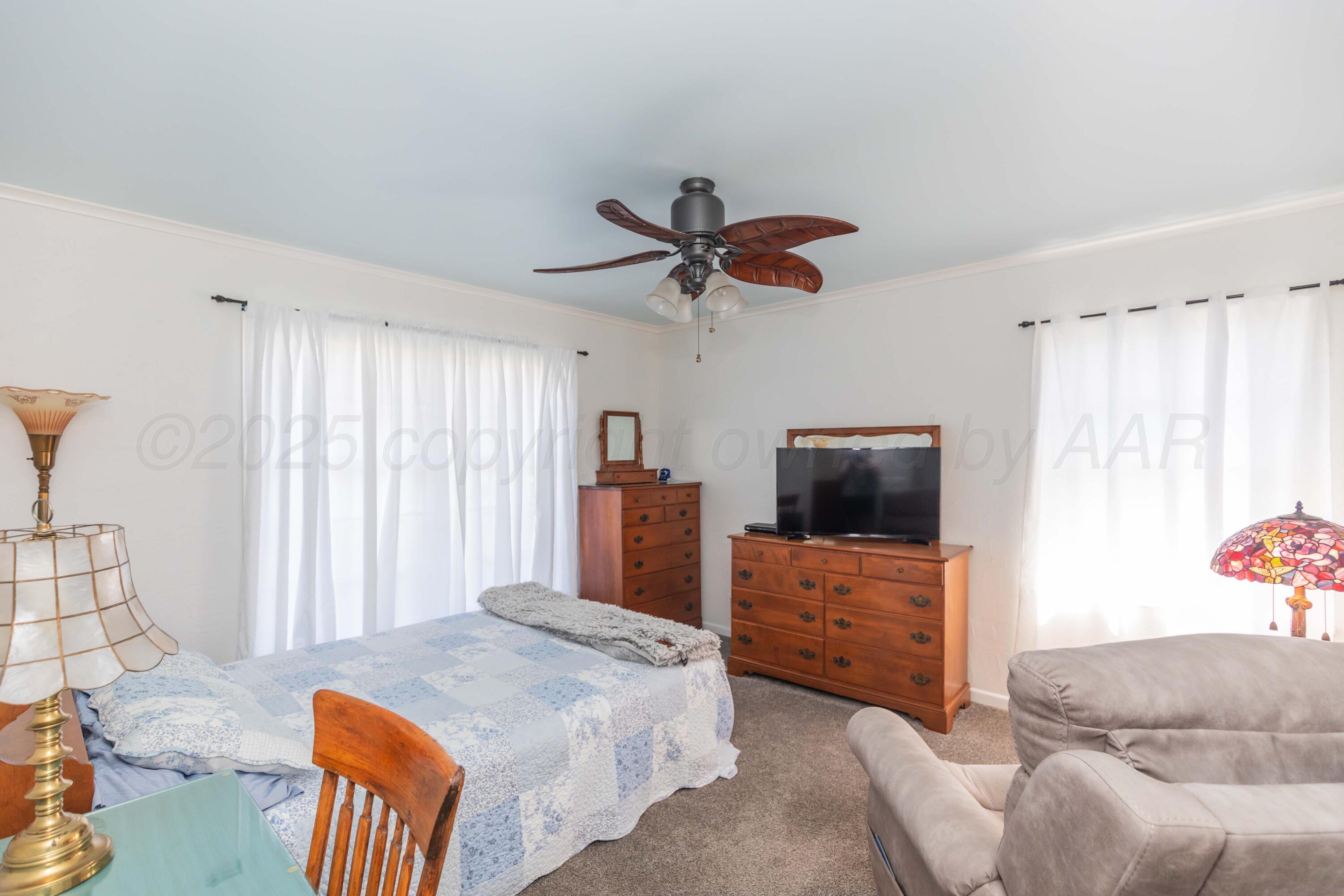 6019 Jameson Road Amarillo, TX 79106 - Photo 42 of 52 a bedroom with furniture and a flat screen tv