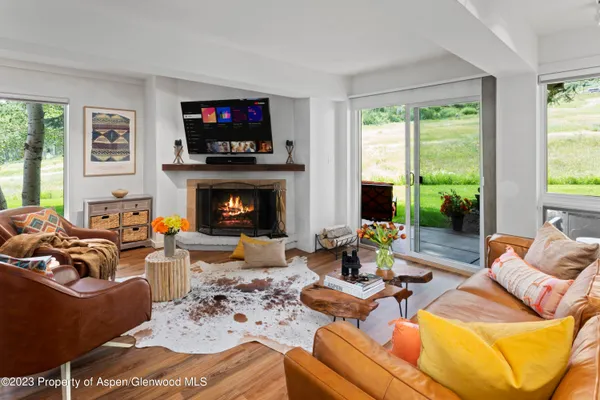 a living room with furniture fireplace and a large window